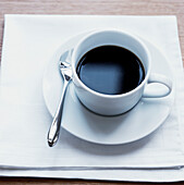 Tasse schwarzer Kaffee in einer weißen Tasse mit Untertasse