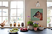 Küchenutensilien und Schüsseln mit frischen Lebensmitteln auf einer Theke mit einem Kuhkopf, in einem Haus in Großbritannien