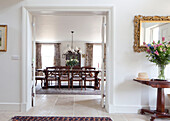 View through double doors to dining room in Wiltshire country house England UK