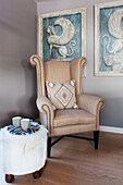 Upholstered armchair and side stool with artwork in Lakes home, England, UK