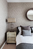 Cream lamp shade with metal base at bedside in Lakes home, England, UK