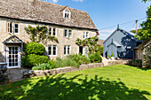 Sonnenbeschienener Garten eines alten Steinhauses in Cirencester Gloucestershire UK