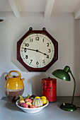 Vintage-Uhr und Lampe mit Obstschale in einem Haus in Cirencester, Gloucestershire, Großbritannien