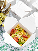 Rice dish with tomatoes and peas in cardboard box Derwent Water, Cumbria, England UK