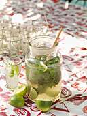 Jam Jar Mojito with lime and fresh mint on tablecloth with LOVE print London England UK