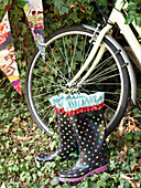 Fleckige Gummistiefel und Vorderrad eines Fahrrads mit Wimpeln London England UK