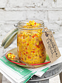 Sweetcorn relish in glass storage jar on dishcloth with label Battersea London UK