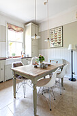 Kleine Pendelleuchten hängen über dem Küchentisch mit DSW-Stühlen in einem Haus in Guildford, Surrey, Großbritannien