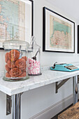 Scourers and sweets in glass storage jars with vintage typewriter and framed maps in Reading home Berkshire England UK