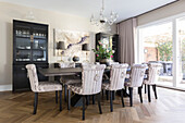 Walnut wood dining table with upholstered chairs in sustainable home Highgate London UK