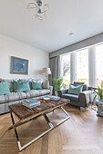 Wooden coffee table and seating with pale turquoise cushions in sustainable newbuild Highgate London UK