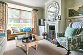 Vintage-Sessel und verzierter Spiegel im Wohnzimmer einer viktorianischen Terrasse Alton UK