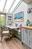 Wooden table and chairs with bench seat in glazed kitchen extension of Victorian terrace Alton UK