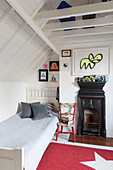 Einzelbett und Decoupage-Stuhl unter der Traufe im Dachgeschoss von Guildford cottage Surrey UK