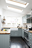 Modern country style kitchen with pastel blue units and skylights