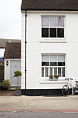 Fahrrad und weiß getünchte Fassade einer Doppelhaushälfte UK