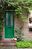 Kürbisse auf der Eingangstreppe mit hellgrüner Eingangstür, East Cowes, Isle of Wight, UK