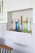 Coloured glass candlesticks on service hatch in Ryde home Isle of Wight, UK