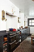 Black kitchen with cobblestone floor in Hastings townhouse East Sussex England UK