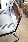 Gestreiftes Sitzkissen auf einem alten Esszimmerstuhl aus Metall und Holz in einem Haus in Brighton, East Sussex, Großbritannien