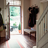 View from open front door leading to garden from the hallway with coat rack on the wall