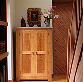 Hallway detail with shaker style wooden cupboard and tongue and groove wood panelling