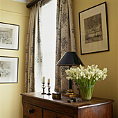 Detail of dressing table with glass vase of white hyacinth flowers