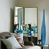 Zimmerecke mit Spiegeltisch und Paravent, hoher blauer Vase und Glasobjekten