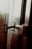 Old key in dark wooden door