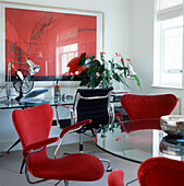 Designer white red and black home office study space with glass tables and fabric covered designer chairs