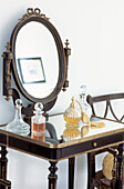 Country style vintage dressing table with ornate glass perfume bottles