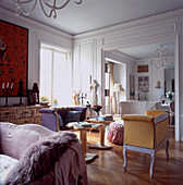 Elegant panelled drawing room with high ceilings with an eclectic mix of furniture on wooden parquet floor