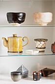 Display of ceramic ornaments on glass shelves in a display cabinet