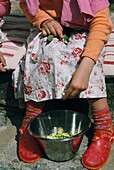 Junges Mädchen schält Saubohnen für das Mittagessen