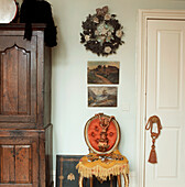 Detail des Wohnzimmers mit Eichenschrank, gepolstertem Stuhl und Garnituren
