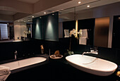 Schwarzes Badezimmer mit verspiegelter Wand und großem Waschbecken
