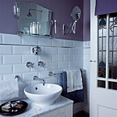 Badezimmer mit weißen Fliesen im Vintage-Stil, lila gestrichenen Wänden und Badezimmer-Accessoires aus Metall