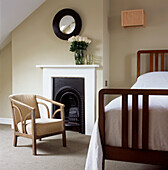 Minimal Victorian style bedroom with bed fireplace and chair