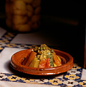 A Moroccan tagine of cooked vegetables in an authentic setting