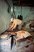 Einheimischer Bäcker beim Brotbacken in seinem Laden in der Medina von Fez, Marokko