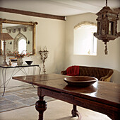 White entrance hall with stone floors and large antique wooden oak table 
