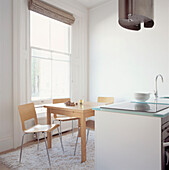 Kitchen dining area in studio apartment with large sash windows