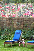 Blaue Liegekissen im Garten mit Weidenzaun und Kunstwerk, London, England, UK