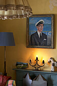 Close up in yellow living room with Sea Captain portrait hanging above the fireplace 