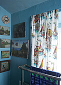 Badezimmer Detail mit naiver Landschaft und nautischen Gemälden und Vintage Bootsstoffvorhängen