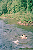 Kinder schwimmen im Fluss