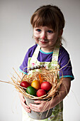 Young girl with bucket of multi-coloured Easter Eggs