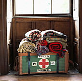 Rolled blankets on medical box in sunlit window of London home, UK