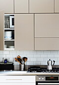 Cafetiere on hob below fitted kitchen units in contemporary London home, England, UK