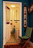 Green folding chair at entrance to bathroom in London home, England, UK